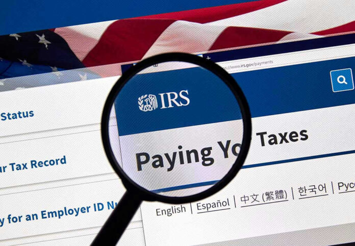 Magnifying glass over IRS website for paying taxes