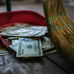 22-Year-Old’s $20/Hour Savings Secret Broom sweeping dollar bills into red dustpan floor