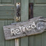 Retirement Playbook DESTROYED — Nobody Saw Coming Wooden Retired sign on an old green door