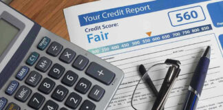 Calculator and glasses on credit report document