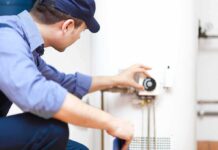Plumber adjusting the settings on a water heater