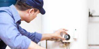 Plumber adjusting the settings on a water heater