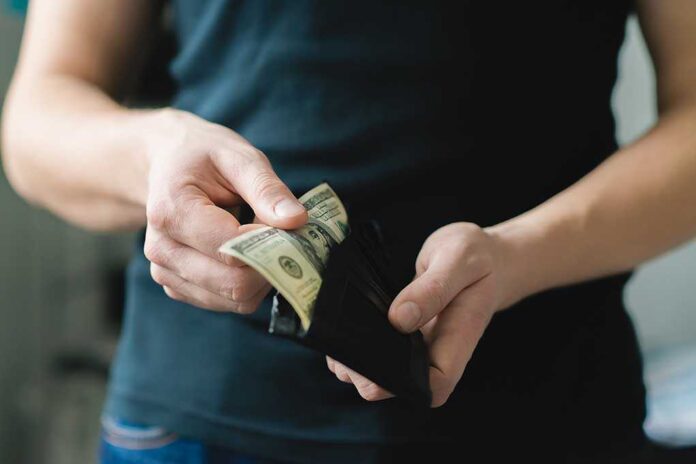 shutterstock_167957741.jpg Person holding a wallet with cash inside