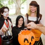INSIDER Tactics for Halloween Costume Wins Children in Halloween costumes collecting candy from a house