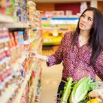 Canned Food MYTH Exploded — Cardiologists Shocked Woman shopping in a grocery store aisle with a cart full of vegetables