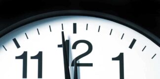 Close up of a clock showing the time just before noon