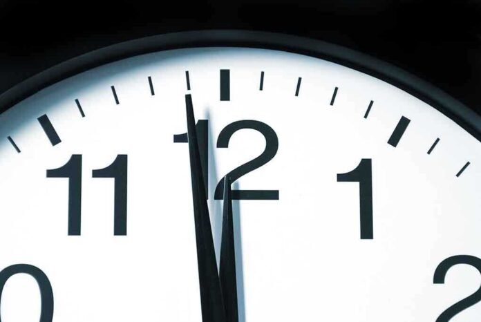 shutterstock_55812874.jpg Close up of a clock showing the time just before noon