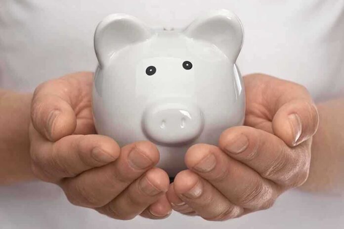 shutterstock_98671160.jpg Hands holding a white ceramic piggy bank