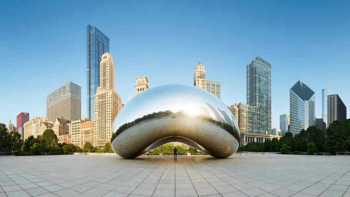 Cloud Gate sculpture with skyline of skyscrapers behind it