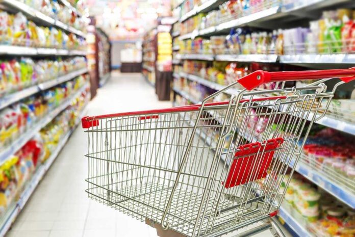 shutterstock_171787895.jpg A shopping cart in a grocery store aisle filled with colorful products