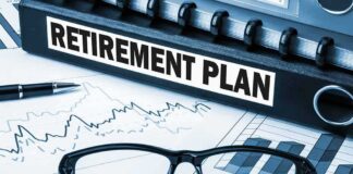 Close up of a retirement plan binder with glasses and financial charts