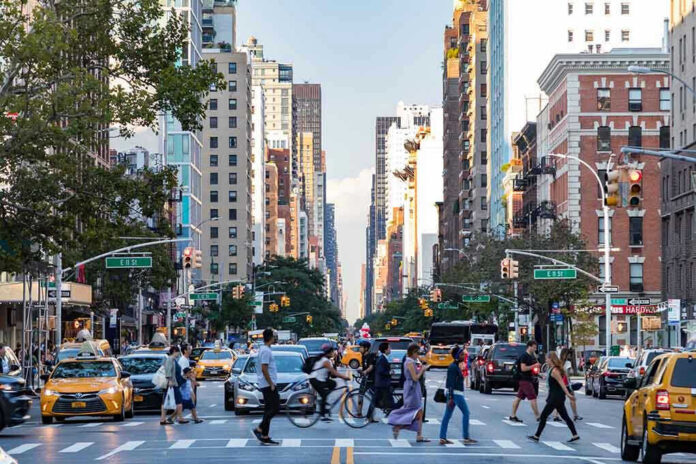 Busy city street with cars and people crossing
