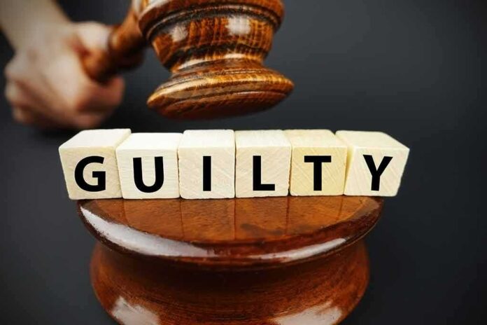 shutterstock_1014820045.jpg A gavel striking down next to wooden blocks spelling 'GUILTY'