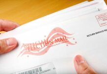 Voting Could Change Forever For These 17 States A hand holding an envelope labeled Official Election Mail