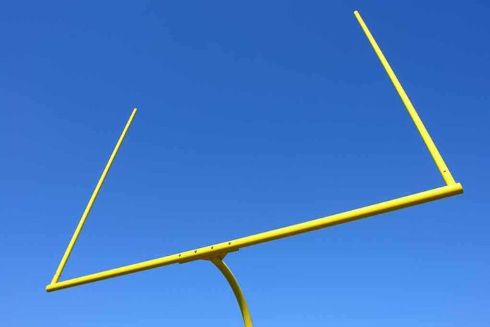 Yellow football goalpost against a clear blue sky