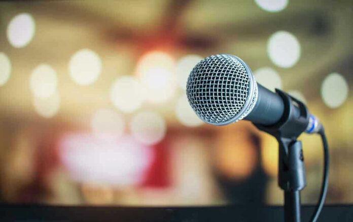 676019521 Microphone with blurred lights in the background.