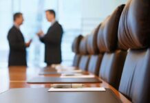 Trump’s Cabinet Blitz — What Biden Couldn’t Do Two business professionals engaged in conversation in a conference room