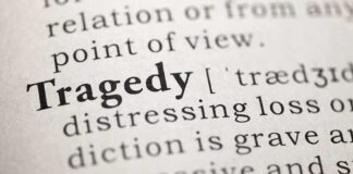 Close-up of a dictionary page showing the definition of 'tragedy'