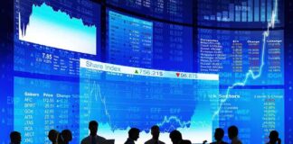 Silhouetted business professionals in front of digital stock market displays