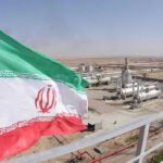 Iranian flag near an industrial gas refinery.