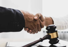 Handshaking near a gavel on desk.