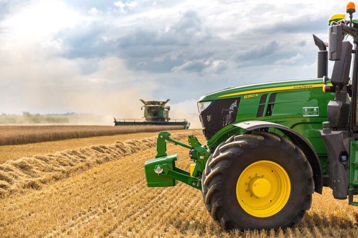 740872495 A green tractor in a wheat field.
