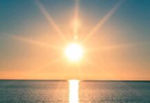 Climate Crisis Intensifies: Dire Warnings A serene sunrise over a calm ocean with vibrant colors in the sky