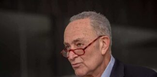 A man with glasses speaking passionately during a public address