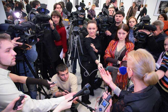 shutterstock_24480769.jpg A crowded press conference with journalists and cameras surrounding a speaker