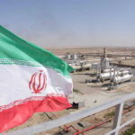 Iranian flag near an industrial gas refinery.