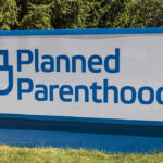 Planned Parenthood sign on a grassy lawn.