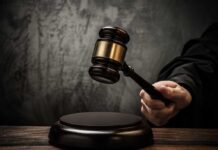 A judges gavel poised to strike a sound block