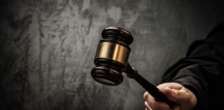 A judges gavel poised to strike a sound block