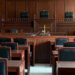 Prison Reform Chaos: NYC’s Dangerous Path Empty courtroom with wooden furnishings and judges bench.