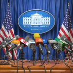 High Stakes: Iran Deal Awaits Trump Nod Multiple microphones at White House press briefing podium.