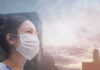 Person wearing a mask in a cityscape background.