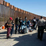 Massive Deportation Drive Sparks Courtroom Showdown Border patrol agents interact with a group of people.