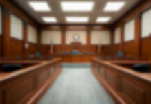 Restraining Orders Failed: Actor’s Terrifying Attack Empty courthouse courtroom with wooden benches and chairs.