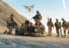 Soldiers operating a drone in a desert environment.