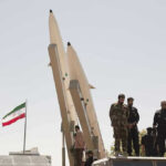 Underground Shelter: Khamenei’s High-Stakes Disappearance Military personnel beside missiles and Iranian flag.