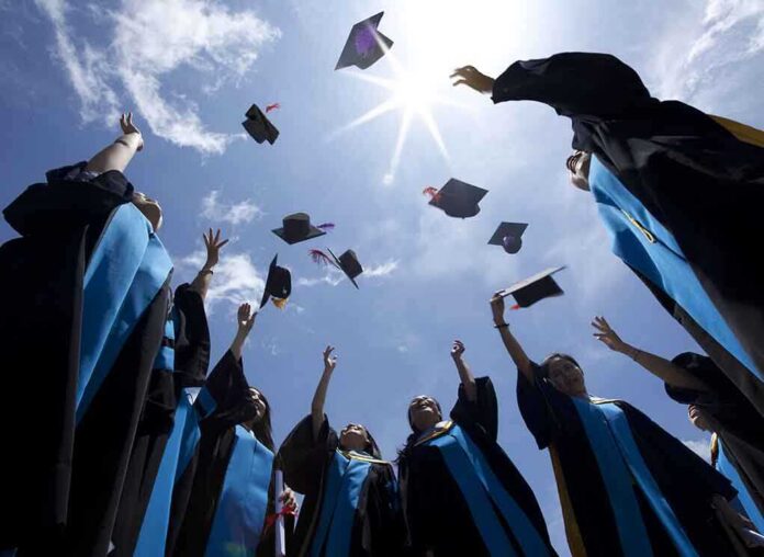 shutterstock_115335829-1 Graduating students celebrating by throwing their caps into the air under a bright blue sky