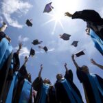 AI Showdown: Former Google CEO Sparks Outrage at Graduation Graduating students celebrating by throwing their caps into the air under a bright blue sky