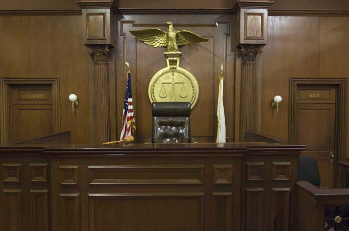 Interior of a courtroom featuring a judges bench and American flag