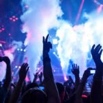 ISIS Plot Foiled: Taylor Swift Fans Saved Crowd at a concert with hands raised and smoke effects in the background