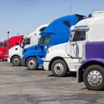 Immigrant Truckers BANNED: Indiana’s Shocking Crackdown A lineup of colorful trucks parked in a lot