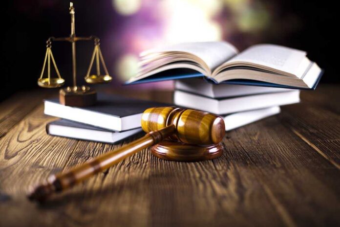 Judge,Gavel A gavel, legal books, and scales of justice on a wooden table