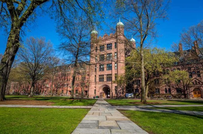 shutterstock_192516893 Historic university building surrounded by green grass and trees under a blue sky