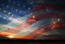 A sunset with an overlay of the American flag and dramatic clouds