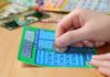 Lottery SHOCKER: Karma Pays Big! A person scratching off a bingo lottery ticket with a coin