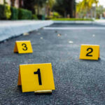 Honduras Massacre: Chilling Chaos Spreads Crime scene markers on asphalt with bullet casing.